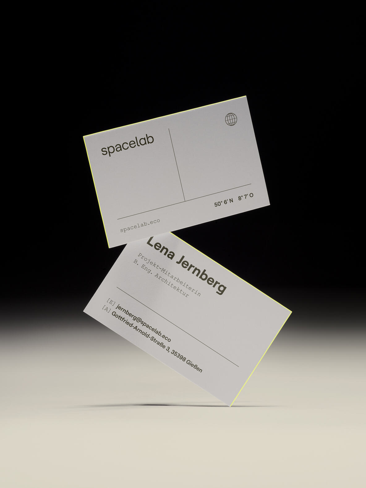 Zwei schwebende Visitenkarten im minimalistischen Corporate Design von Spacelab mit schwarzer Typografie auf weißem Hintergrund.